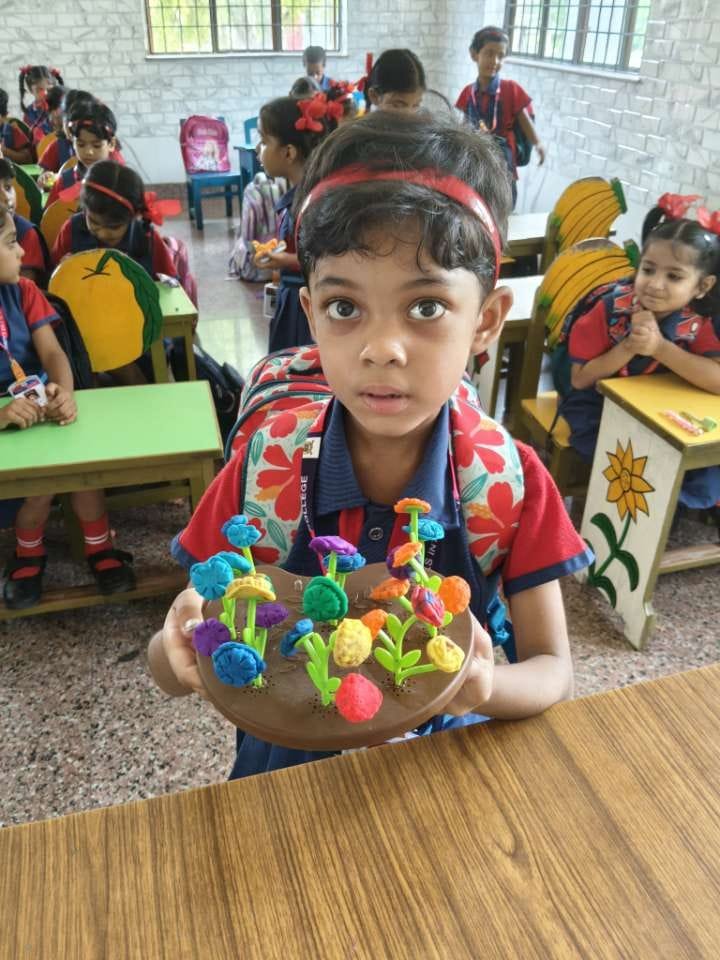 A student proudly showing off her clay craft project